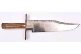 A Bowie knife, massive heavy clipped back blade 11?, the hilt with staghorn grips and 5? flat bronze