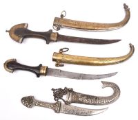 2 Arab jambiyas, wooden hilts with sheaths and hilt mountings of brass and WM overlay; and another