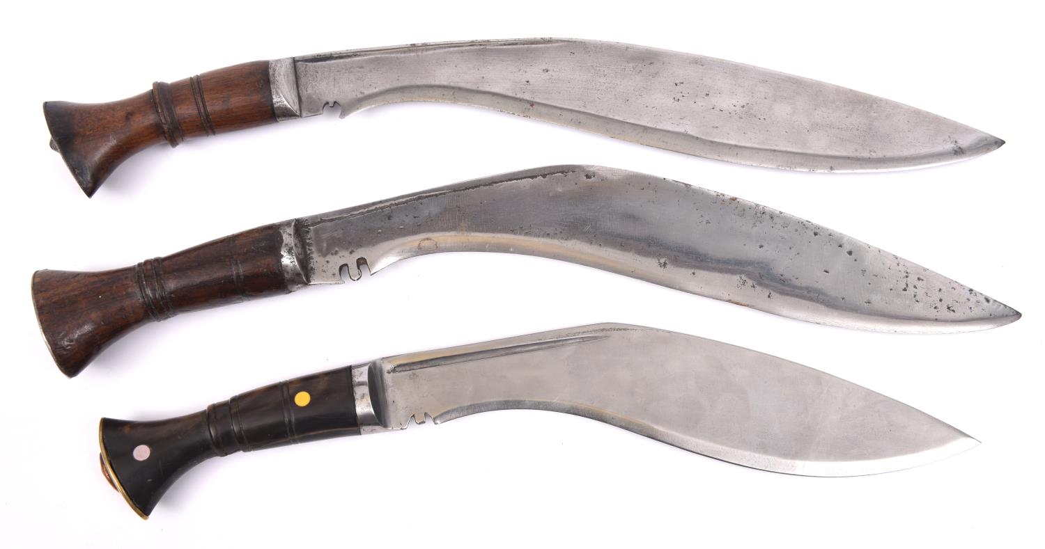 Two kukris with plain wood hilts, and another, with horn hilt inset with bone discs, and with