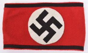 A Third Reich NSDAP armband, red cloth with applique swastika and braiding, RZM paper label on