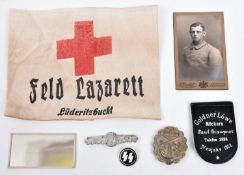 A Third Reich SS enamelled lapel badge; an alloy Luftwaffe badge; WWI Feld Lazaret armband; Imperial