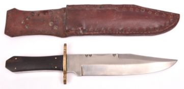 A heavy Bowie knife, clipped back blade 9½" with partly scalloped back edge, the hilt with brass
