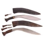 A kukri, with plain wood hilt, in its leather covered sheath with two companion knives; and