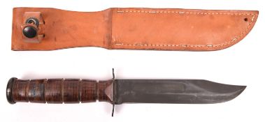 A US Navy Mark 2 Ka-Bar utility knife, with blade Parkerised blade, in its pale leather sheath.