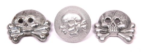 Two metal skulls from SS collar patches, and an SS sidecap button with Assmann mark, RZM and SS