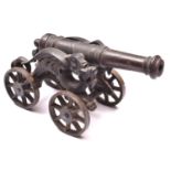 A decorative iron cannon, barrel 15" (not bored through), on its four wheeled iron carriage with