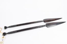 A pair of decorative African short ebony spears, 26" overall, with bands of spirally fluted