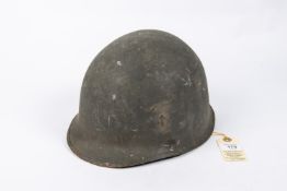 A WWII US Steel helmet, complete with lining and original combat finish. GC £40-50