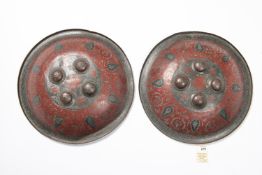A pair of Indian Benares brass shields, 14" diameter, decorated overall with leaves and tendrils