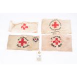 A Third Reich Red Cross arm band, 3 more varying types and an enamel badge. GC £50-60