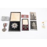 A Third Reich German cross in its case; a Waffen SS man's belt buckle; a WWI Iron Cross 1st class; a