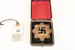 A Third Reich Deutsches Kreuz (German Cross) in gold, of six rivet construction, the pin stamped "