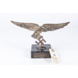 A Third Reich Luftwaffe desk ornament, in the form of a white metal Luftwaffe eagle mounted on a