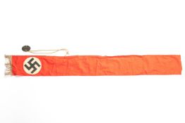 A Third Reich funeral sash of silver alloy, fringed red material, 50" x 6", swastika motif; also