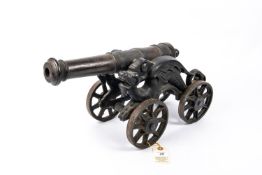 A decorative iron cannon, barrel 15" (not bored through), on its four wheeled iron carriage with
