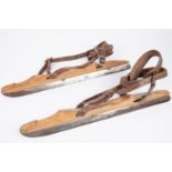 A pair of vintage ice skates, wooden bodies with steel blades marked "J. Nooitgedagt & Zn Ljist",