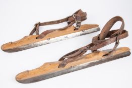 A pair of vintage ice skates, wooden bodies with steel blades marked "J. Nooitgedagt & Zn Ljist",