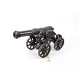 A decorative iron cannon, barrel 15" (not bored through), on its four wheeled iron carriage with