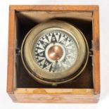 A Ship's brass compass by Norie & Wilson, London. Mounted on a gimball in a wooden box with