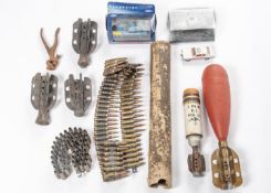 A 3" mortar bomb (incomplete); a similar 2" mortar bomb; a linked belt of inert 7.62 cartridges; 3