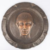 A WWII hammered copper plaque 16¾" diameter depicting full face and steel helmet of a Polish