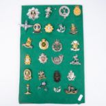 Twenty three various cap badges, including silver coloured Ryl West Kent officers, the Scottish