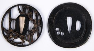 A Japanese cast brass tsuba, pierced and embossed with reeds and bamboo; and a plain blackened