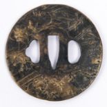 A Japanese cast brass tsuba, blackened on one side and embossed overall with rural scene. GC £50-60