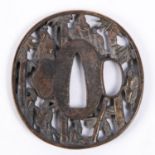 A Japanese brass tsuba, pierced and embossed with figures and bamboo and with 2 line signature.