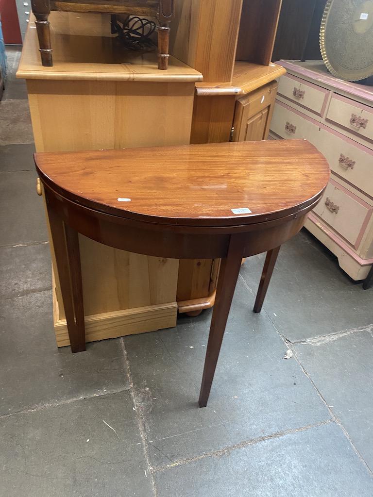 A mahogany demi-lune fold top tea table.