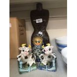 A pair of cow ornaments/bookends, tohether with a Russian Doll and a ceramic female torso