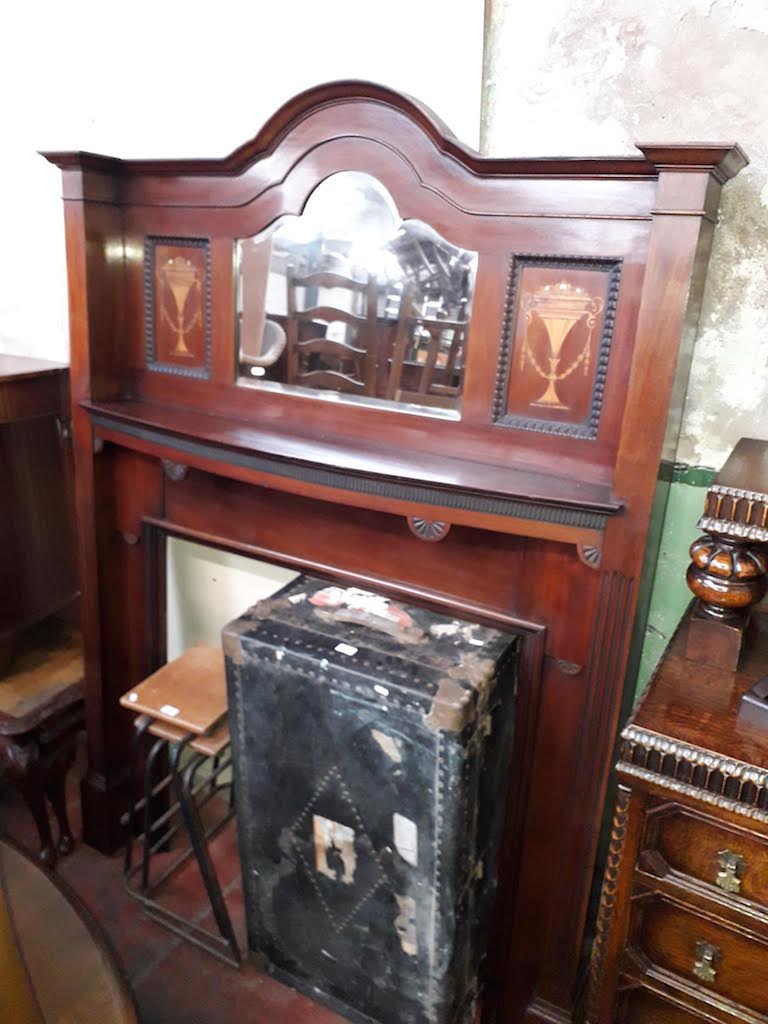 An Edwardian inlaid mahogany and mirror back fire surround.