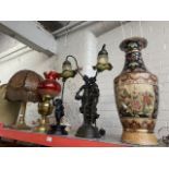 A large vase lamp, 2 figural lamps, a paraffin lamp with cranberry glass shade and funnel and a