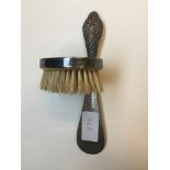A small brush with silver rim and a silver handled shoe horn.