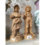 A pair of pottery figures of boy and girl, marked R&L