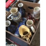 A box of ceramic tankards and vases