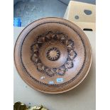 A terracotta wall hanging dish ornately decorated