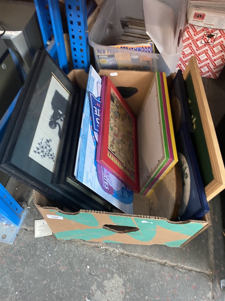 A box of pictures and enameled metal signs.