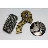 Three modernist brooches comprising a Danish pewter brooch no. 907 by Georg Jensen, a Rosenthal