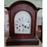 A domed mantel clock with pendulum and key.
