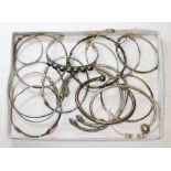 A tray of assorted silver and white metal bangles, various marks, gross wt. 189g.