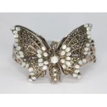 A white metal butterfly bangle set with marcasite and moonstones, unmarked, gross wt. 45.76g,