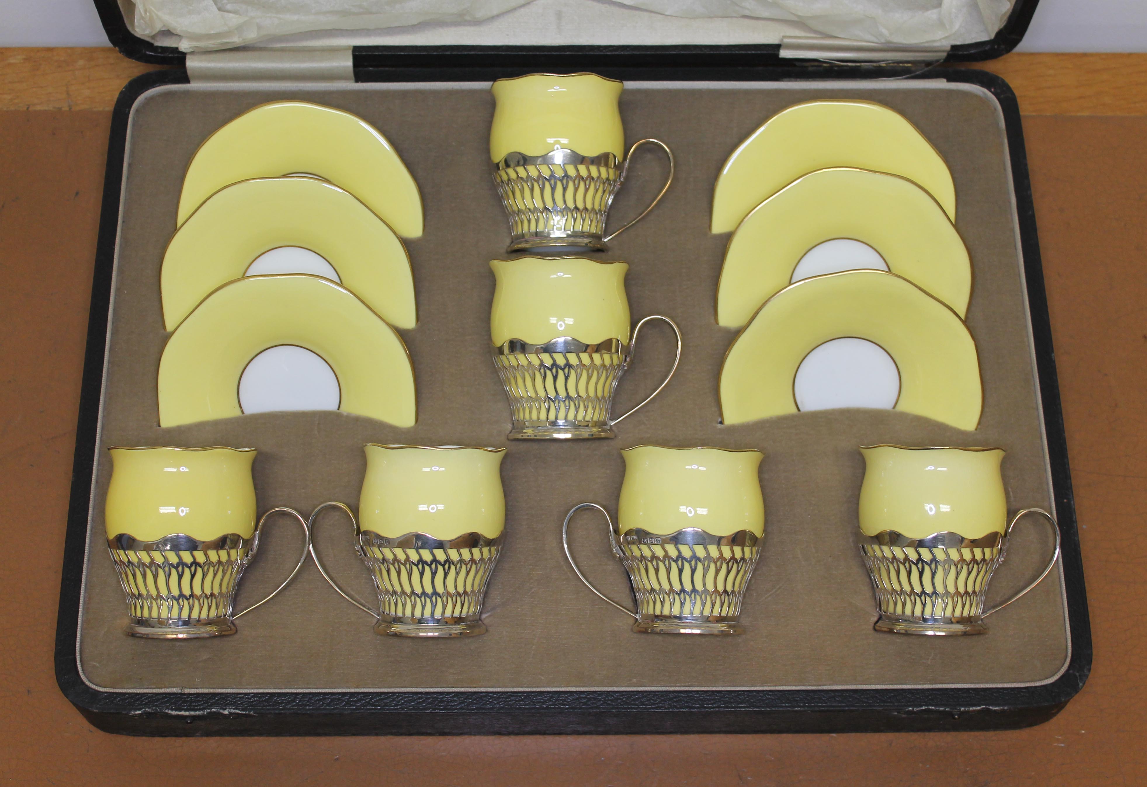 A cased set of six hallmarked silver mounted coffee cans and saucers.