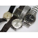 A group of four wrist watches comprising a Roamer, Record De Luxe, Seiko 5 black dial and Ingersoll.