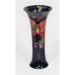 A Moorcroft pottery vase of slender form with flared rim decorated in pomegranate pattern, height