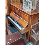 A Steinway & Sons mahogany upright piano.