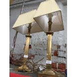 A pair of brass column table lamps with shades.