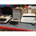 A Brother AX-210 typewriter, a vintage Antares portable typewriter and a vintage Erika typewriter.
