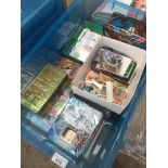 A box containing full tins of Pokemon and Yu Gi Oh cards, collectors cards and stickers from the