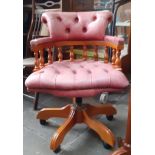 A red leather button back desk chair.